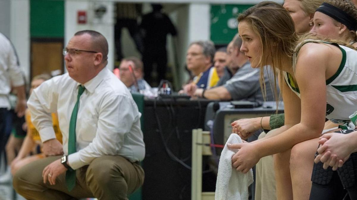 Brandon and Montana Muravchick watch the game against the Franklin County Lady Flyers from the Western Hills bench.
