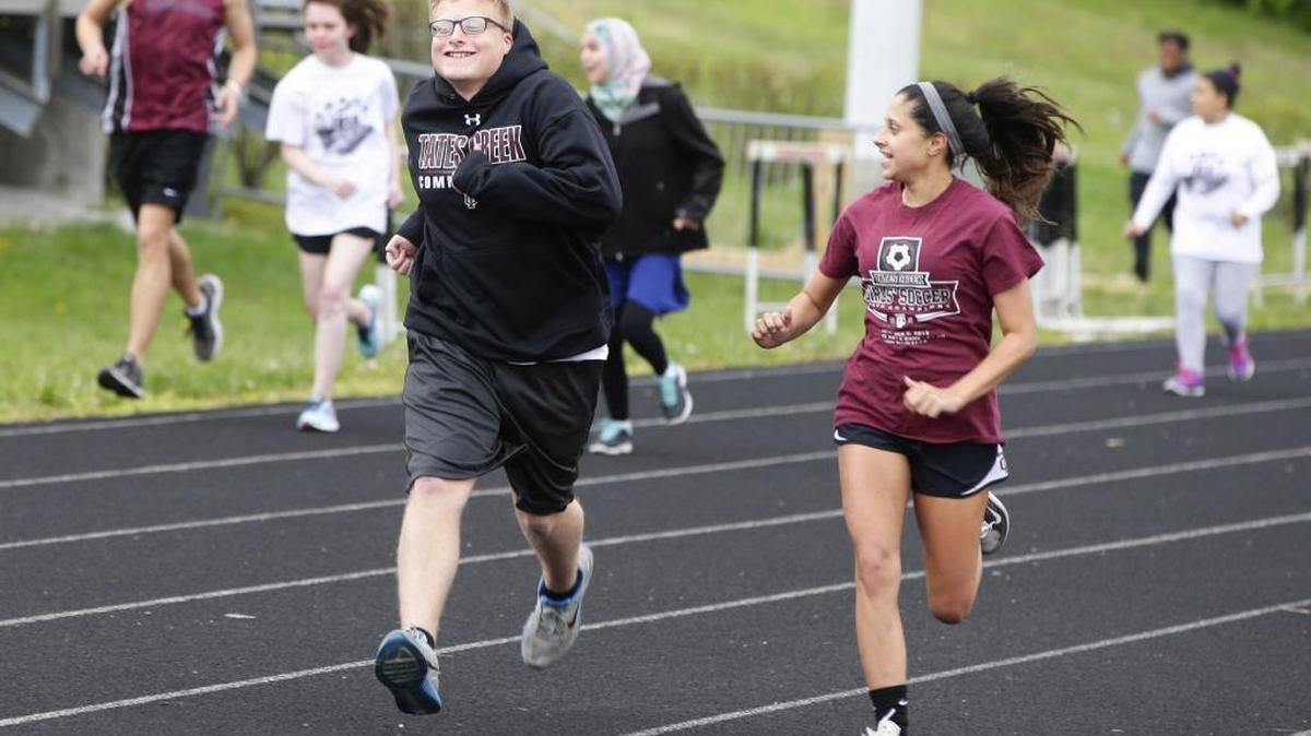 Walker Redmon left, ran with Sarah Jordan as he won the unified track 100-meter dash at the Commodore Classic at Tates Creek on Monday, April 11, 2016, in Lexington.