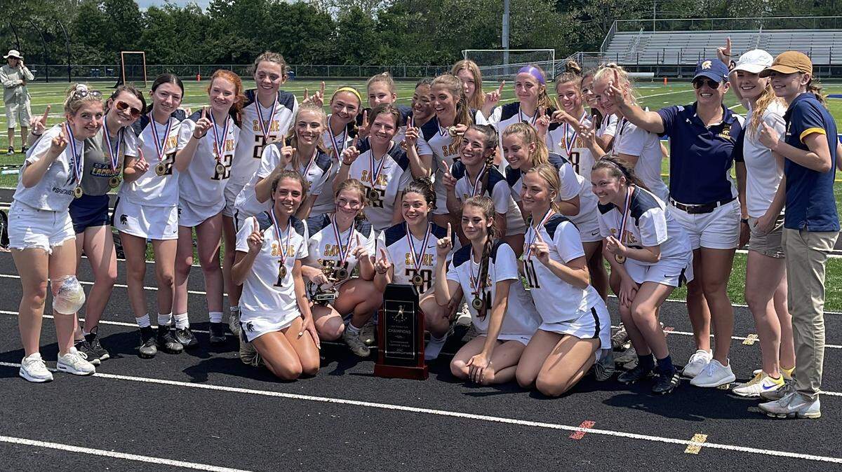 Sayre’s girls’ lacrosse team celebrates with the Commonwealth Lacrosse League girls’ state championship trophy after the Spartans 18-2 win the finals on Saturday, May 14, 2022 at Henry Clay High School in Lexington.