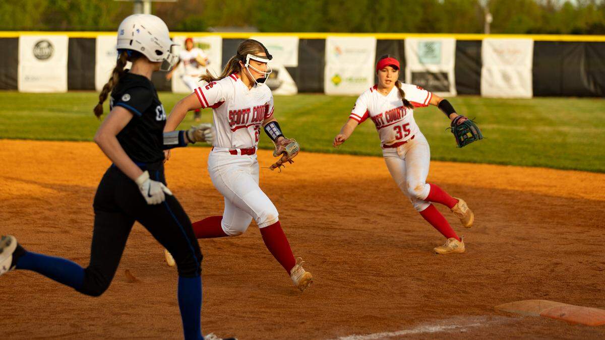 Scott County’s Gracie Strong, center, outraced Lexington Catholic’s Sydney Ford to first base as Cardinals’ second baseman Hadley Swint trailed the play that ended a bases-load threat in the bottom of the sixth inning during the Cardinals’ 3-1 win over the Knights at Scott County High School in Georgetown on Tuesday.