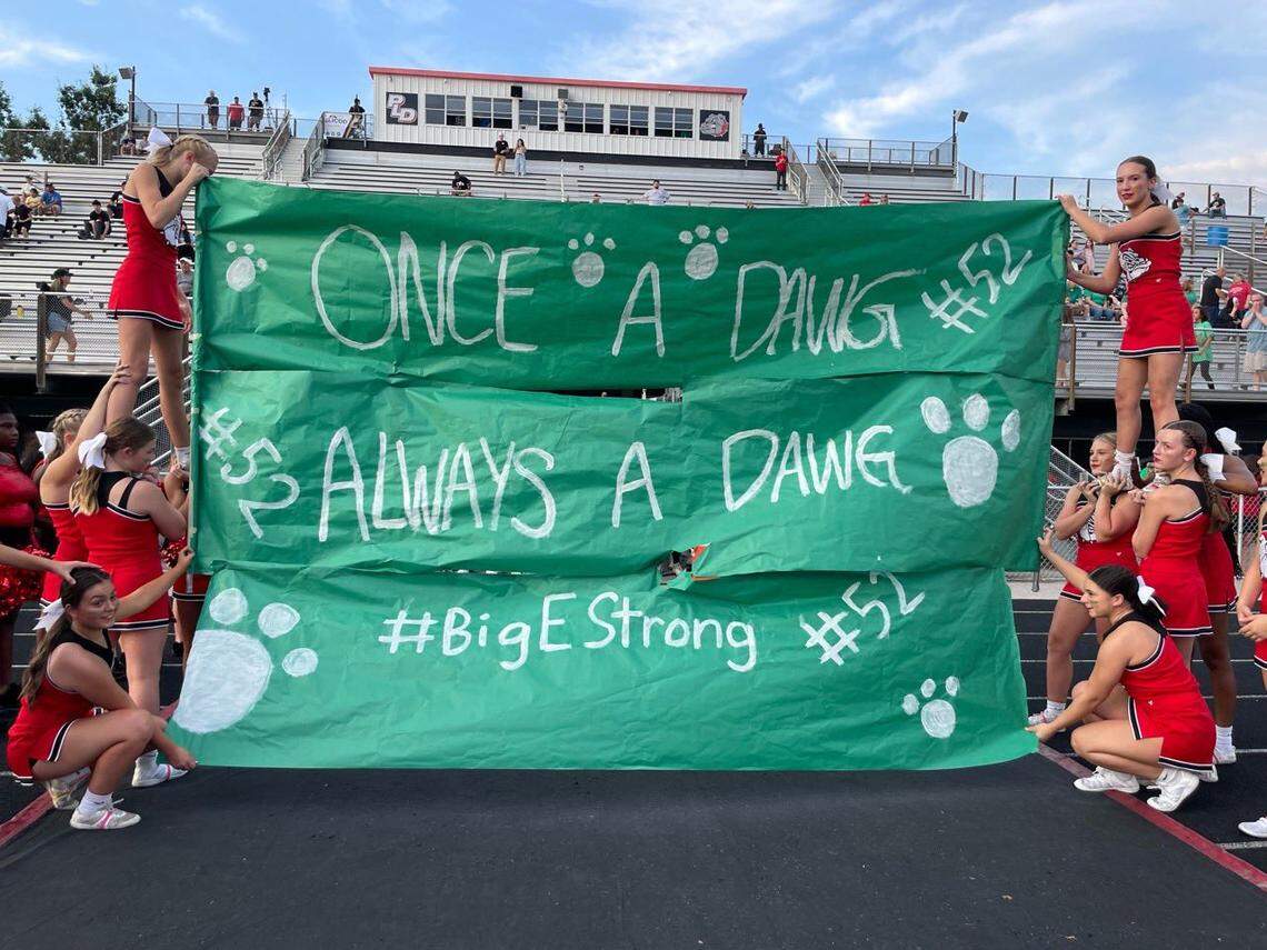 Paul Laurence Dunbar’s cheerleaders held up a banner in tribute to Ethan Hampton for the team to run through ahead of their game against Collins on Sept. 1.