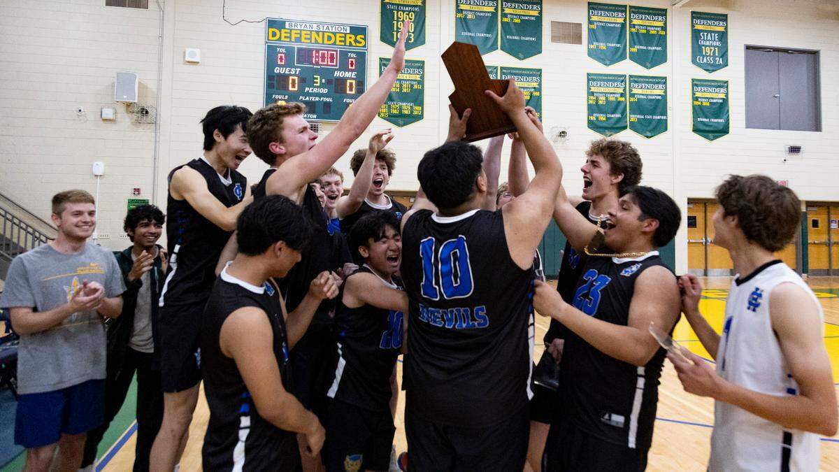 Henry Clay players celebrate as teammate Estaban Velasco-Urbina (10) brings over the 7th Region boys volleyball tournament championship trophy after the Blue Devils’ 3-0 win over Lafayette in the finals at Bryan Station High School on Monday.
