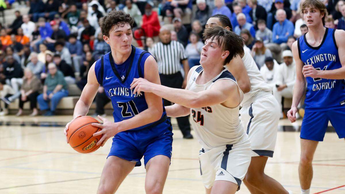 Lexington Catholic’s Rowen Williams (21) tried to get around the defense of Frederick Douglass’ Logan Busson in the boys 11th Region Tournament semifinals at Paul Laurence Dunbar High School on Saturday.
