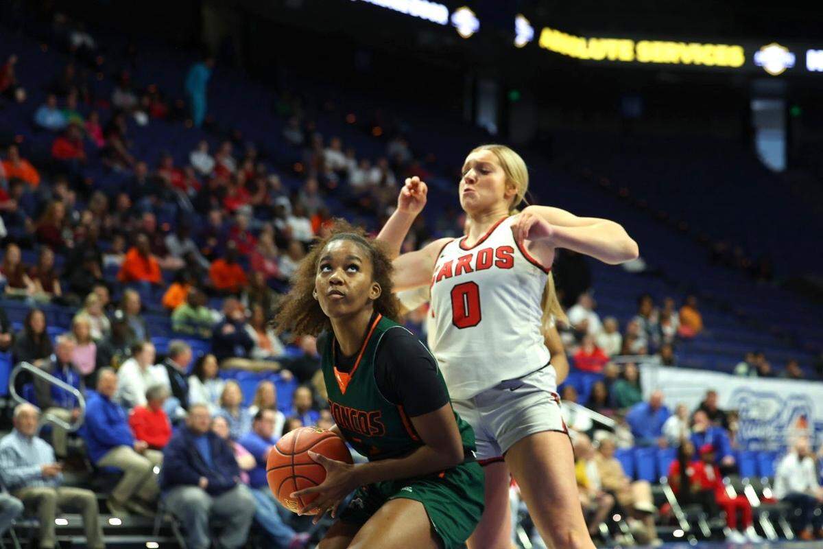 Frederick Douglass’ Peighton Okorley, left, looks to get a shot up through the defense of George Rogers Clark’s Kennedy Stamper during the Clark’s Pump-N-Shop Girls’ Basketball state tournament semifinals at Rupp Arena on Saturday.