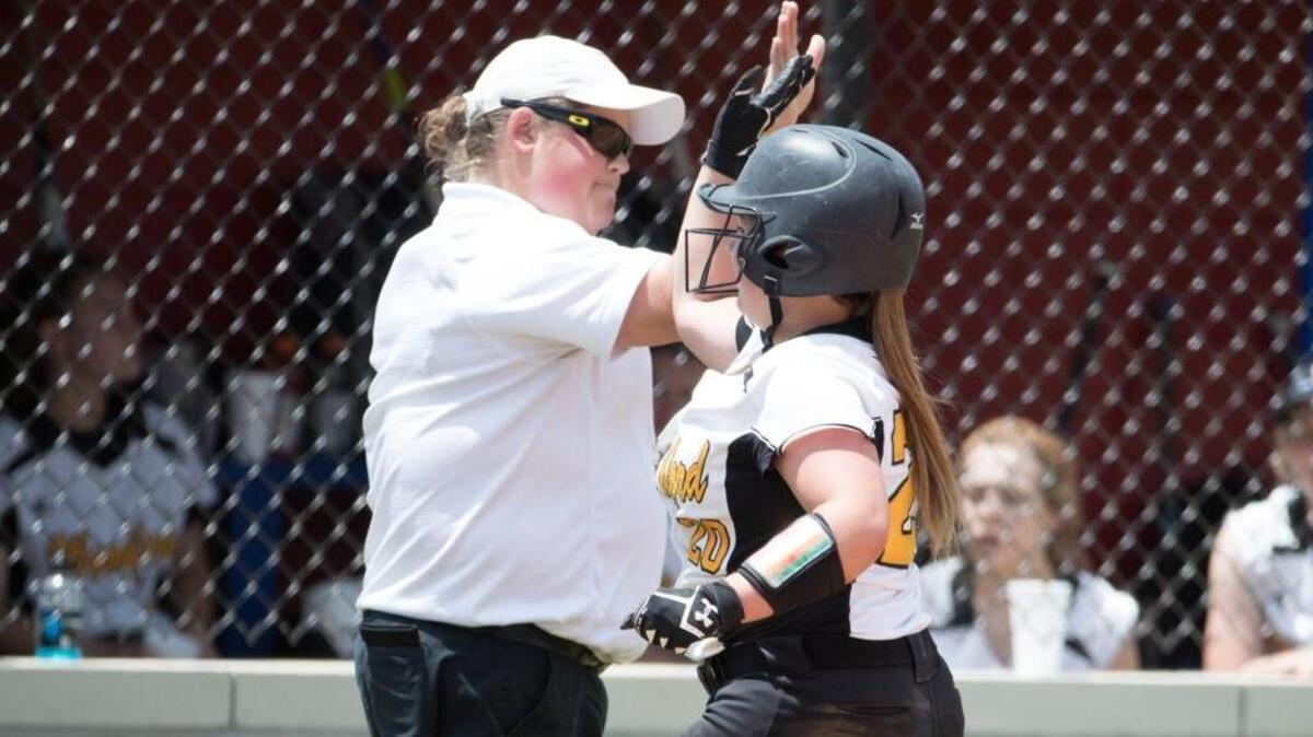 Woodford County’s Paige Hampton got a high-five from Coach Sasha Turansky. Hampton had two hits and a sacrifice fly for three RBI in the 7-0 win over Henry Clay in the 11th Region first round.