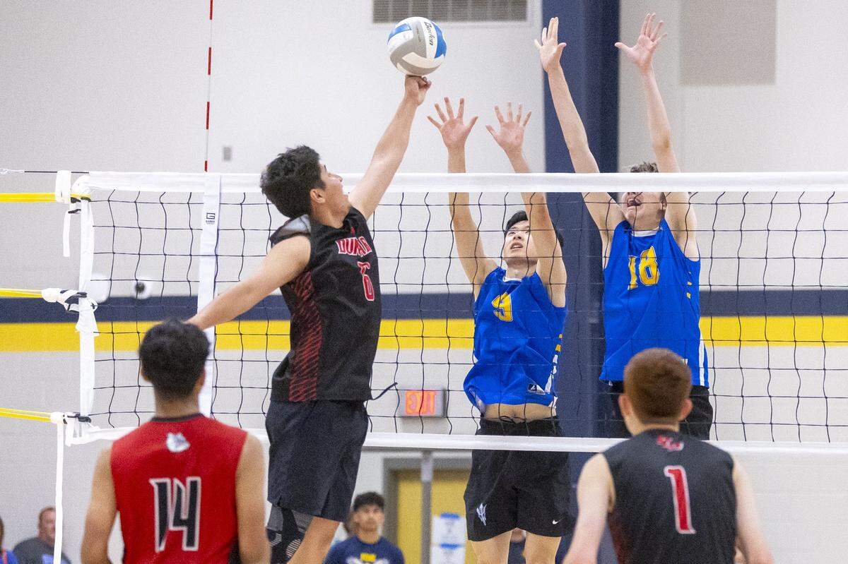Paul Laurence Dunbar’s Esteban Diaz hits the ball as Henry Clay’s Isaac Liang and Clayton Mangione block during the Region 7 boys volleyball tournament semifinals at Franklin County High School in Frankfort, Ky., on Wednesday, May 6, 2026.  