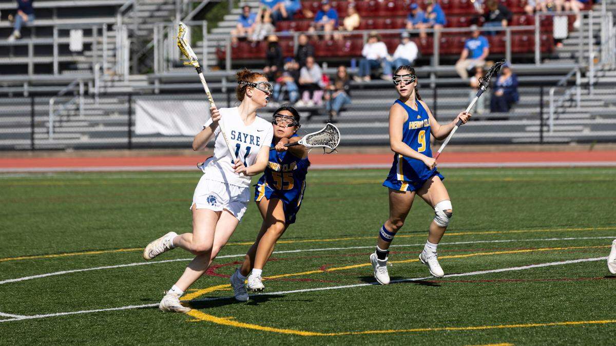 Sayre’s Hadley Luring carries the ball forward while chased by Henry Clay’s Annie Doan during the Spartans’ 15-8 win at Transylvania University’s Pat Deacon Stadium in the state tournament quarterfinals on Saturday.