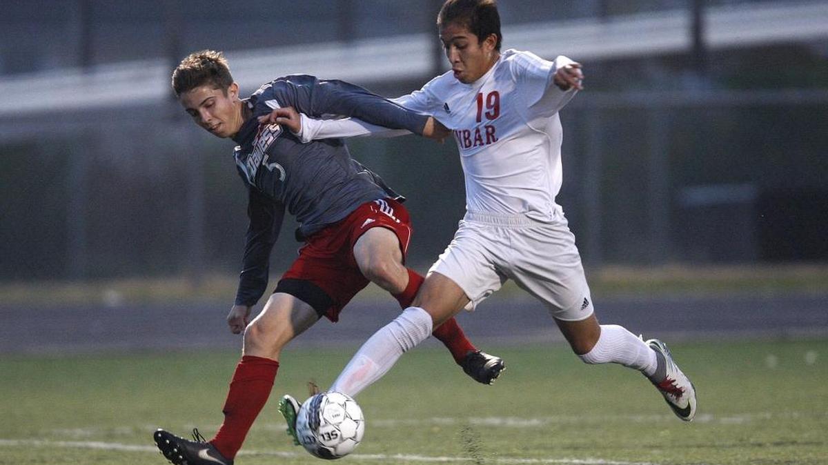 Paul Laurence Dunbar's Pedro Jiminiz dribbles against Daviess County's Jackson Connor in the KHSAA state soccer semifinals at R. L. Grider Stadium in Lexington, Ky., Thursday, November 3, 2016.
