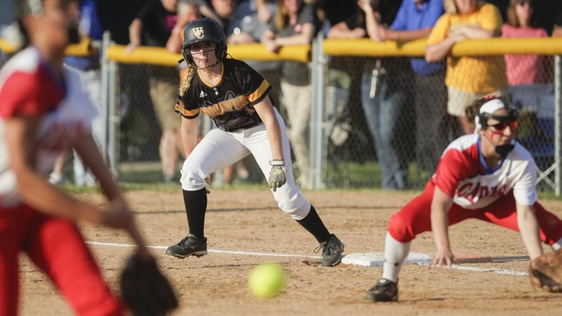 Scott County's Kennedy Sullivan (4) pitches the ball and Cee Wittry (3) plays defense as Woodford's Lexi Bramwell (11) prepares to steal first during the Woodford County Yellowjackets vs the Scott County Lady Cards softball game at Franklin County High School on Tuesday, May 30, 2017 in Frankfort, Ky. The Yellowjackets defeated the Lady Cards 1-0.