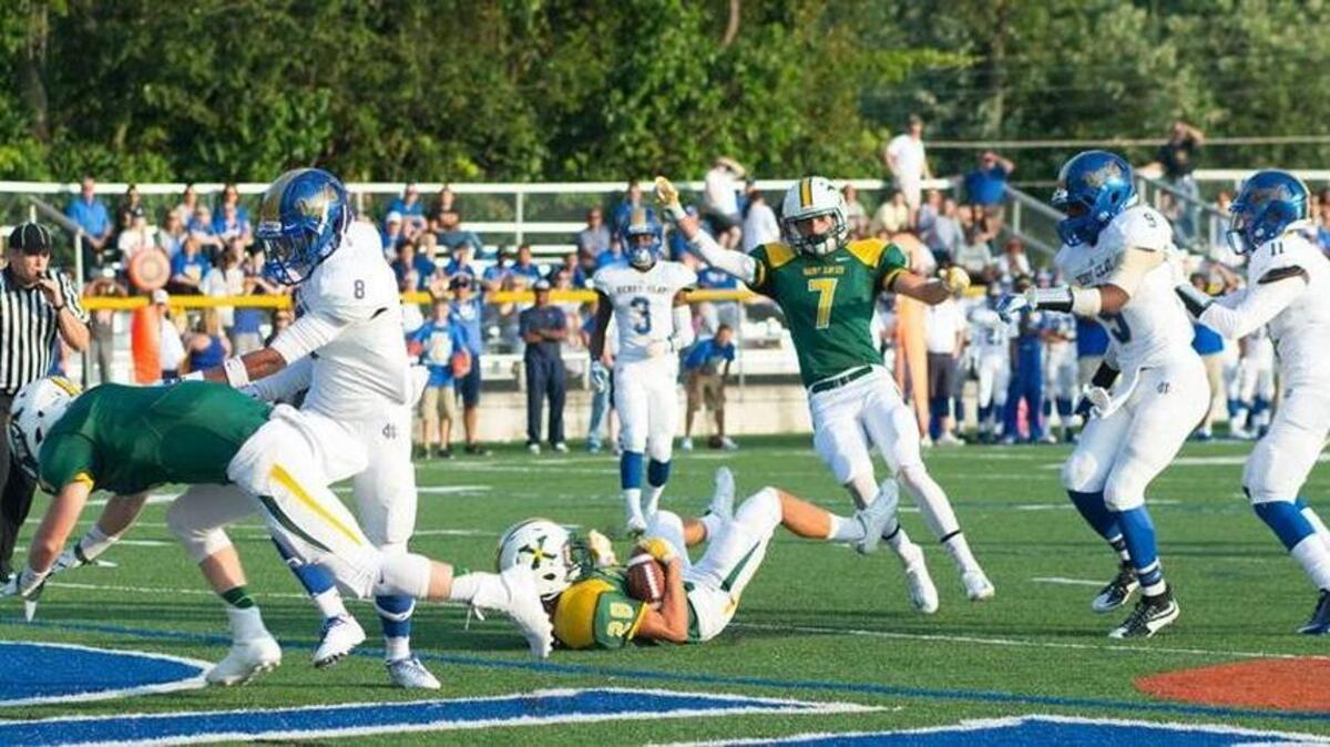 St. Xavier receiver Trey Clements, center is pushed into the end zone for a touchdown in the first half. Henry Clay hosted St. Xavier at Lexington Catholic High School, Friday, Aug. 28, 2015 in Lexington, Ky.