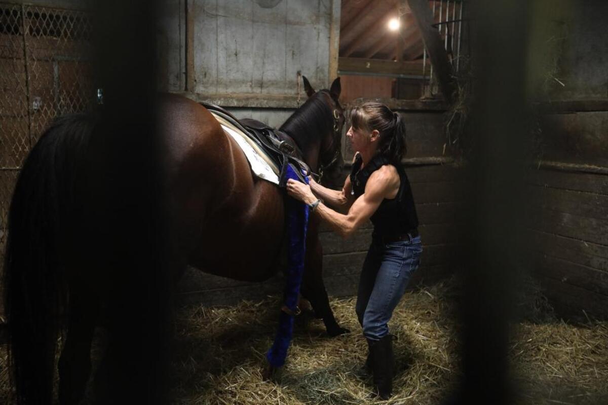 Stefanie Vetter saddles Deja at the North American Racing Academy barn prior to her first breeze as a rider on the training track at the The Thoroughbred Center on Paris Pike in Lexington, Ky., Thursday, August 31, 2017.