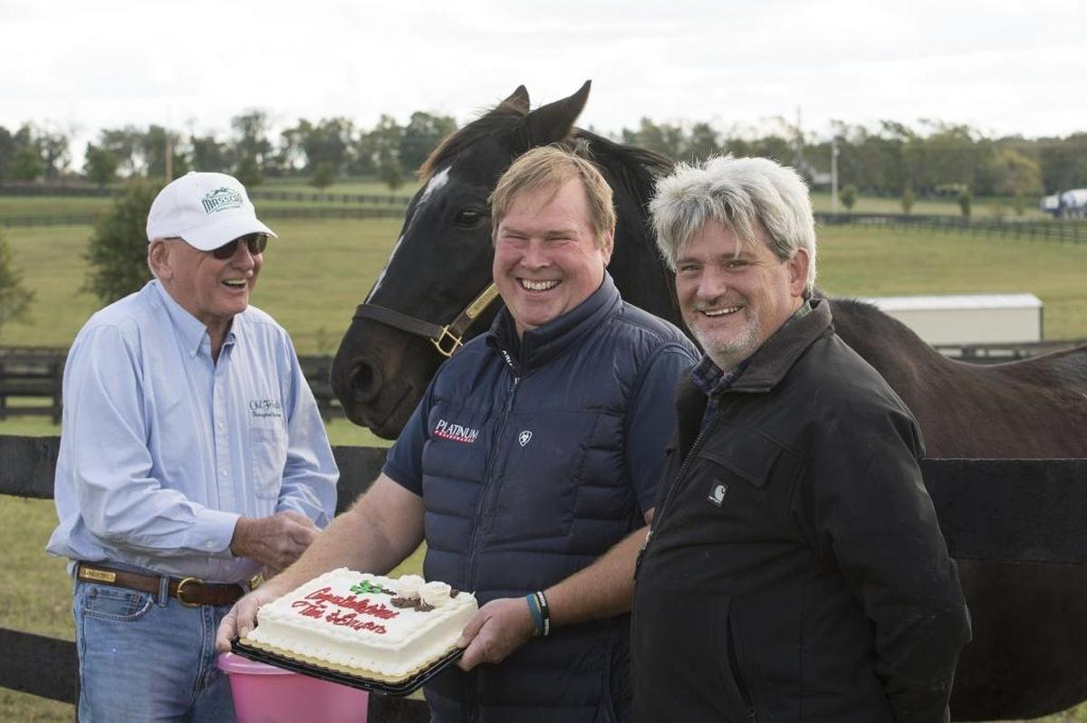 Michael Blowen fed carrots to Kentucky Derby winner War Emblem at Old Friends Equine after presenting a congratulatory cake to Old Friends veterinarian Bryan Waldridge and farm manager Tim Wilson. Waldridge is owner of War Eagle’s Love who won Friday at Keeneland; Wilson, right, is the filly’s trainer.