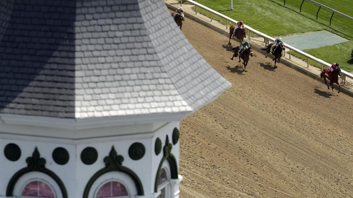 Horses ran past Churchill Downs’ twin spires during an early race on Kentucky Oaks Day on Friday.