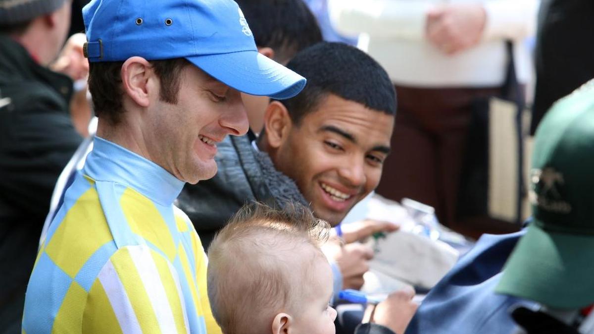 Julien Leparoux held a young fan while taking part in Jockey Autograph Signing Day at Keeneland.