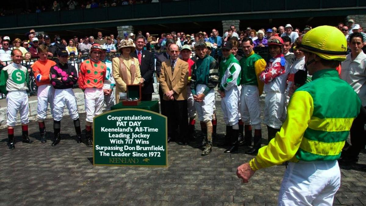 Jockey Pat Day (right) talked to race-goers and other jockeys after surpassing Don Brumfield’s record of 716 wins at Keeneland, a record that Brumfield held since 1972. Day rode Unbridled Time to victory in the second race on April 19, 2000.