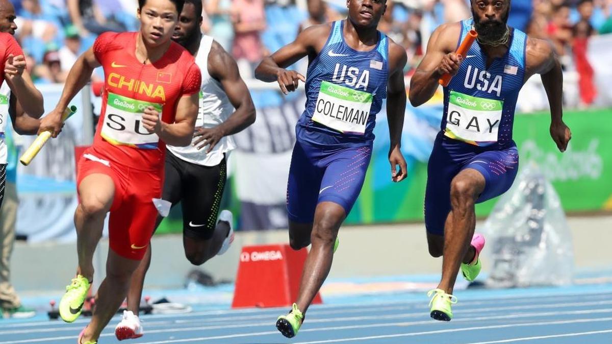 United States' Tyson Gay, right, takes the baton from Christian Coleman, center, as they competes in a men's 4x100-meter relay heat during the athletics competitions of the 2016 Summer Olympics at the Olympic stadium in Rio de Janeiro, Brazil, Thursday, Aug. 18, 2016.