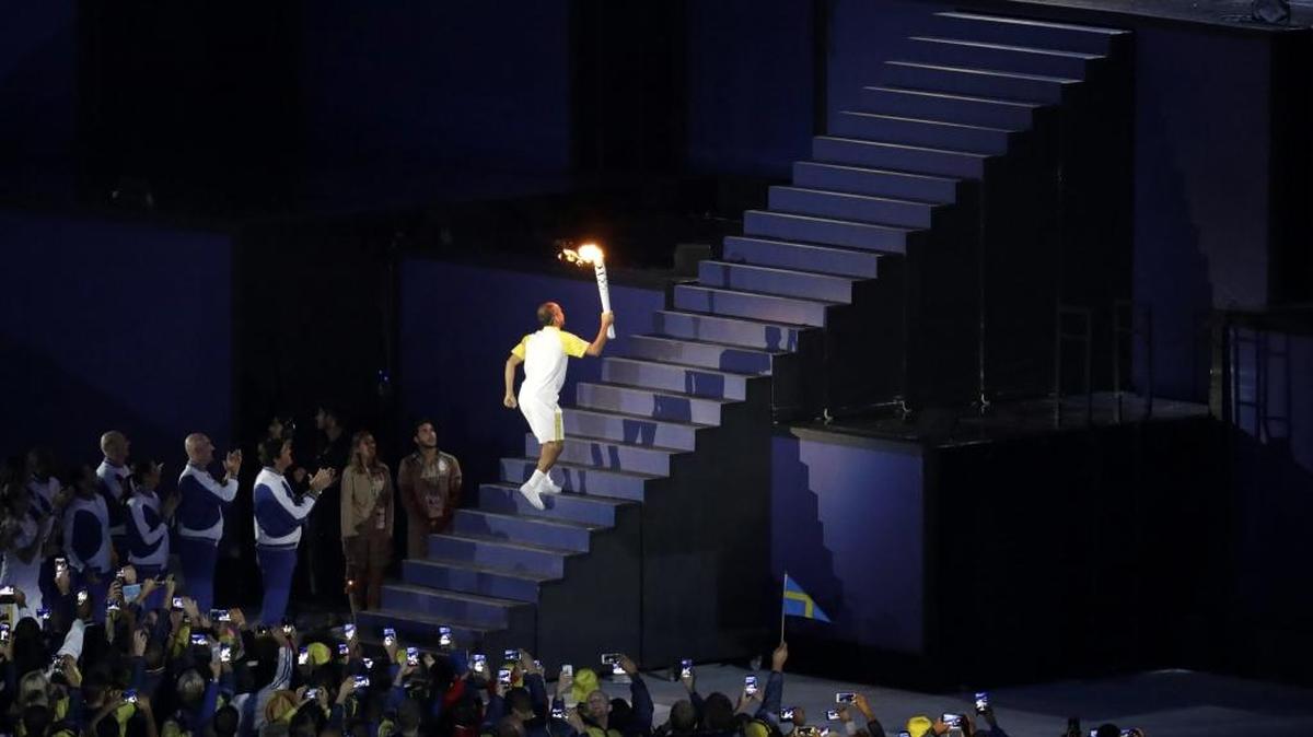 Brazilian marathoner Vanderlei de Lima runs up the step with the Olympic flame during the opening ceremony for the 2016 Summer Olympics in Rio de Janeiro, Brazil, Friday, Aug. 5, 2016.