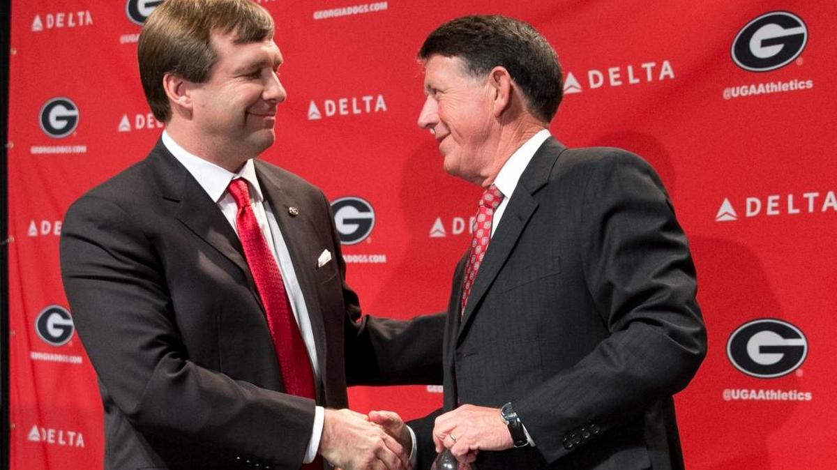 Alabama defensive coordinator Kirby Smart, left, speaks to Georgia athletic director Greg Mcgarity after during a press conference where he was introduced as Georgia's new head football coach Monday, Dec. 7, 2015, in Athens, Ga. Smart will stay with the Crimson Tide through the NCAA college playoffs.