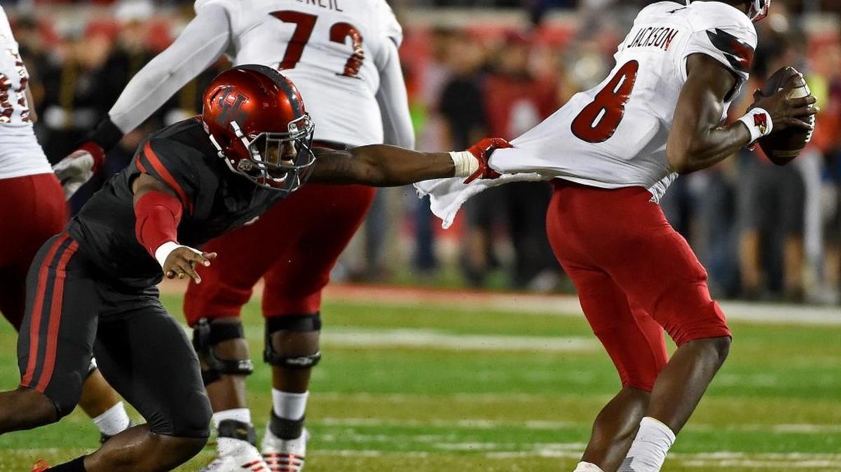 Houston safety Garrett Davis, left, tries to tackle Louisville quarterback Lamar Jackson during the second half of Houston’s 36-10 win over U ofL on Thursday, Nov. 17, 2016, in Houston.