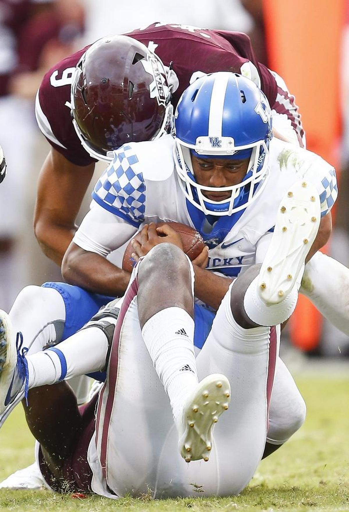 Kentucky quarterback Stephen Johnson (15) was sacked by Mississippi State defensive lineman Montez Sweat (9) and linebacker Dezmond Harris (11) during UK’s 45-7 loss at Davis Wade Stadium in Starkville on Saturday, Oct. 21, 2017.