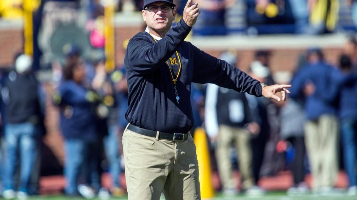 Michigan head football coach Jim Harbaugh directs his players on the field during warmups before his team’s game against Cincinnati, in Ann Arbor, Mich. on Sept. 9, 2017.