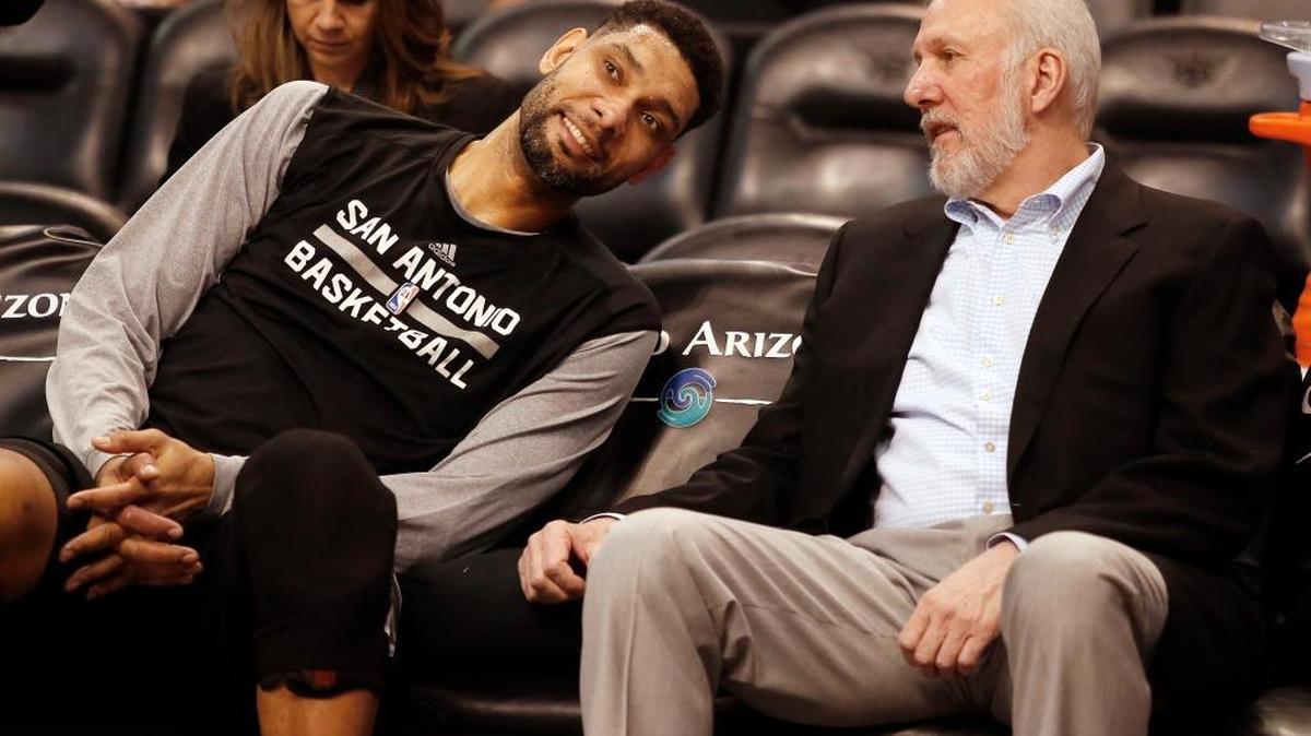 In this Feb. 28, 2015, file photo, San Antonio Spurs forward Tim Duncan, left, and head coach Gregg Popovich chat on the bench during the first quarter of an NBA basketball game against the Phoenix Suns in Phoenix. They were joined at the hip for 19 years, a player and coach combination that enjoyed more wins than any in NBA history.