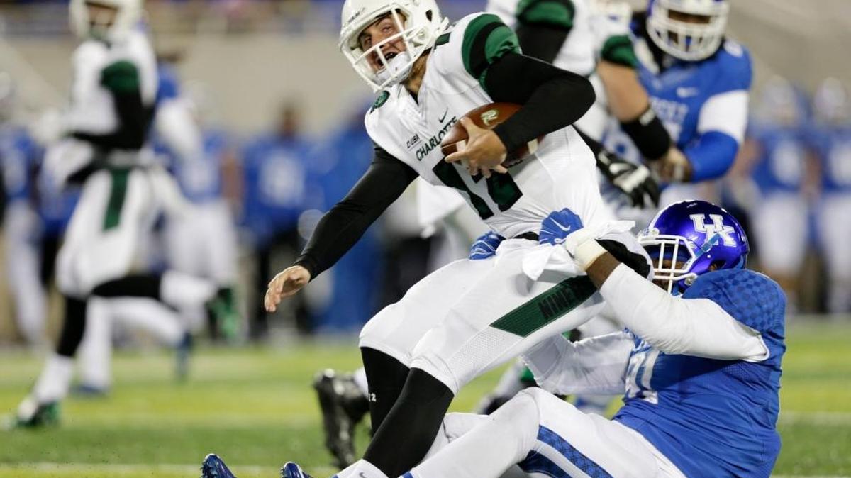 Kentucky defensive end Farrington Huguenin (91) sacked Charlotte quarterback Brooks Barden (12) in the second quarter of the Charlotte at Kentucky football game at Commonwealth Stadium Lexington, Ky, on Nov. 21, 2015.