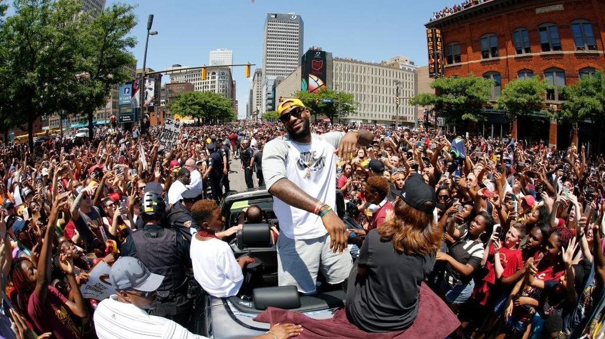 Cleveland Cavaliers' LeBron James, center, stands in the back of a Rolls Royce as it makes it way through the crowd lining the parade route in downtown Cleveland, Wedensday, June 22, 2016, celebrating the Cleveland Cavaliers' NBA Championship.
