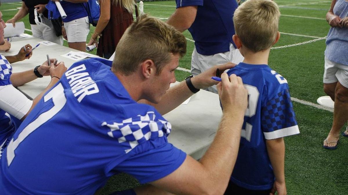Quarterback Drew Barker signed Lane McConathy’s jersey during UK Football Fan Day inside Nutter Field House on Saturday.