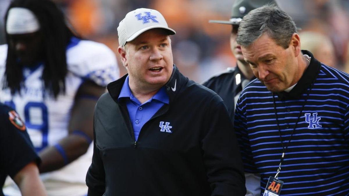 Kentucky football coach Mark Stoops, left, and UK Athletics Director Mitch Barnhart, right, have presided over an ascension in the Wildcats’ football fortunes that began yielding positive results in 2016.