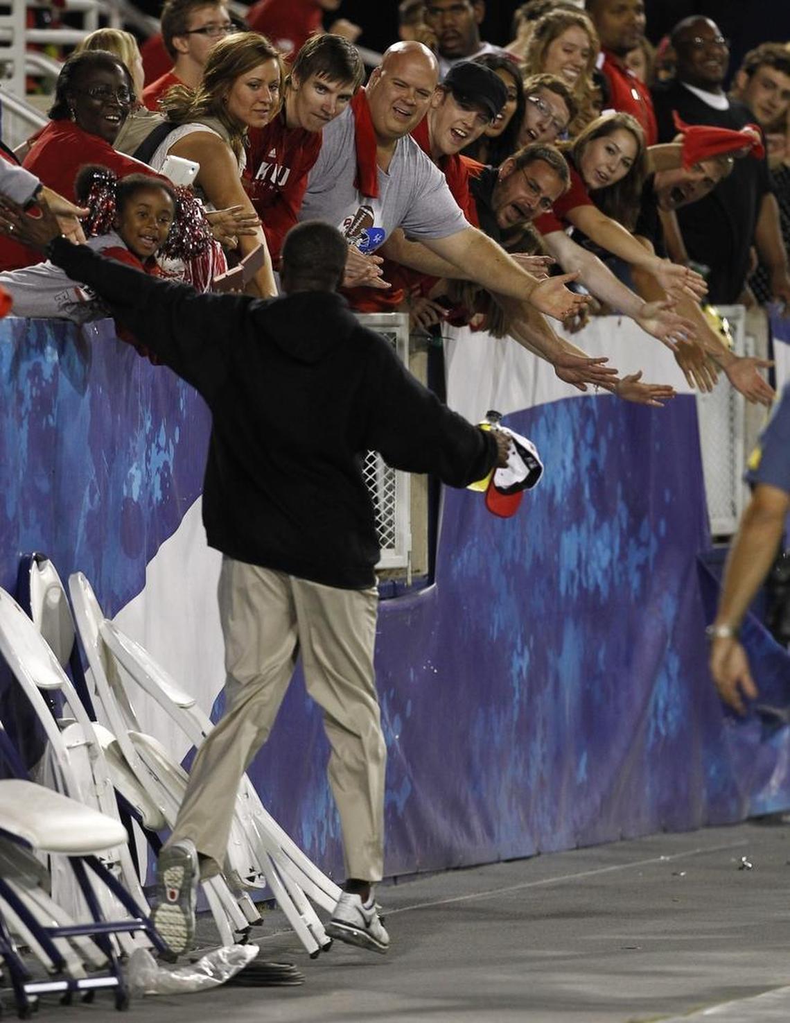 Willie Taggart, the Western Kentucky Hilltoppers football coach in 2012, slapped five with WKU fans in Commonwealth Stadium after Western converted a two-point conversion in overtime to beat Kentucky for the first time ever, 32-31.