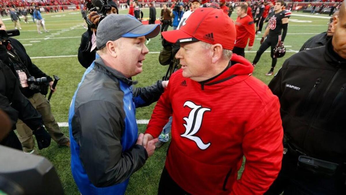 Both Kentucky Coach Mark Stoops, left, and Louisville Coach Bobby Petrino have an acute need to win Saturday’s 24th modern renewal of the Governor’s Cup rivalry between the Wildcats and Cardinals.