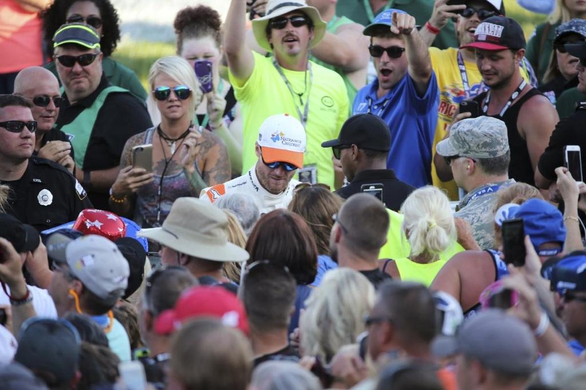 Dale Earnhardt Jr., center, in white and orange, signed autographs after he was introduced for the Quaker State 400 on Saturday night.