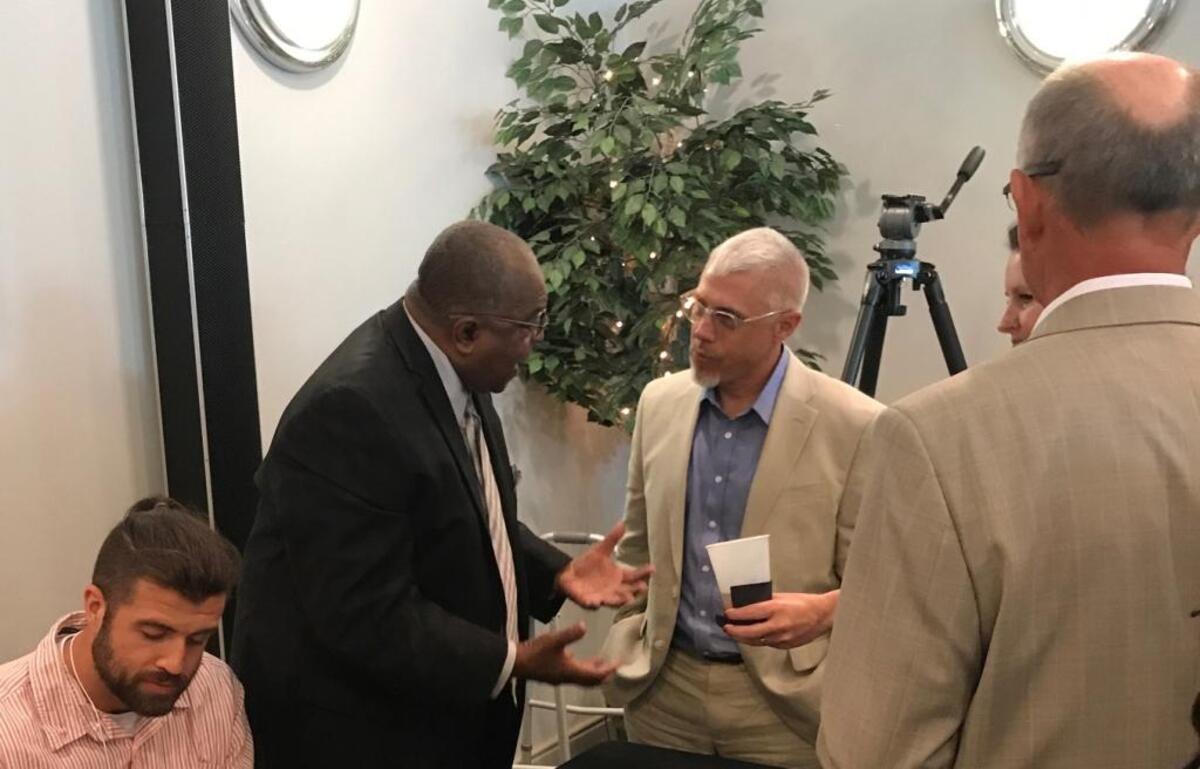 Former Dunbar guard and Bryan Station coach Bobby Washington, left, talked with Paul Laurence Dunbar Coach Scott Chalk before Washington was inducted into the Kentucky High School Basketball Hall of Fame.