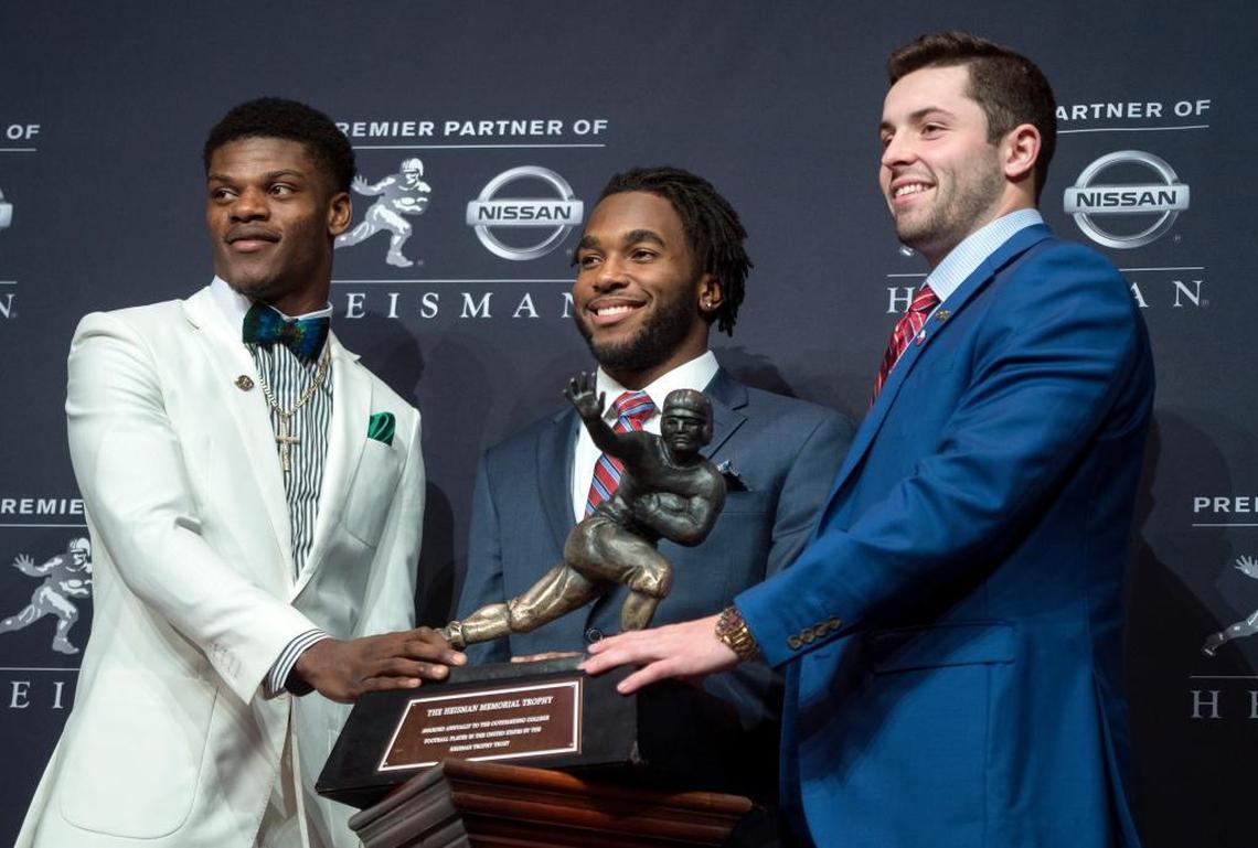 The 2017 Heisman Trophy finalists, from left, Louisville quarterback Lamar Jackson, Stanford running back Bryce Love and Oklahoma quarterback Baker Mayfield posed with the trophy before Mayfield was announced as the winner. Jackson was the 2016 Heisman Trophy winner.