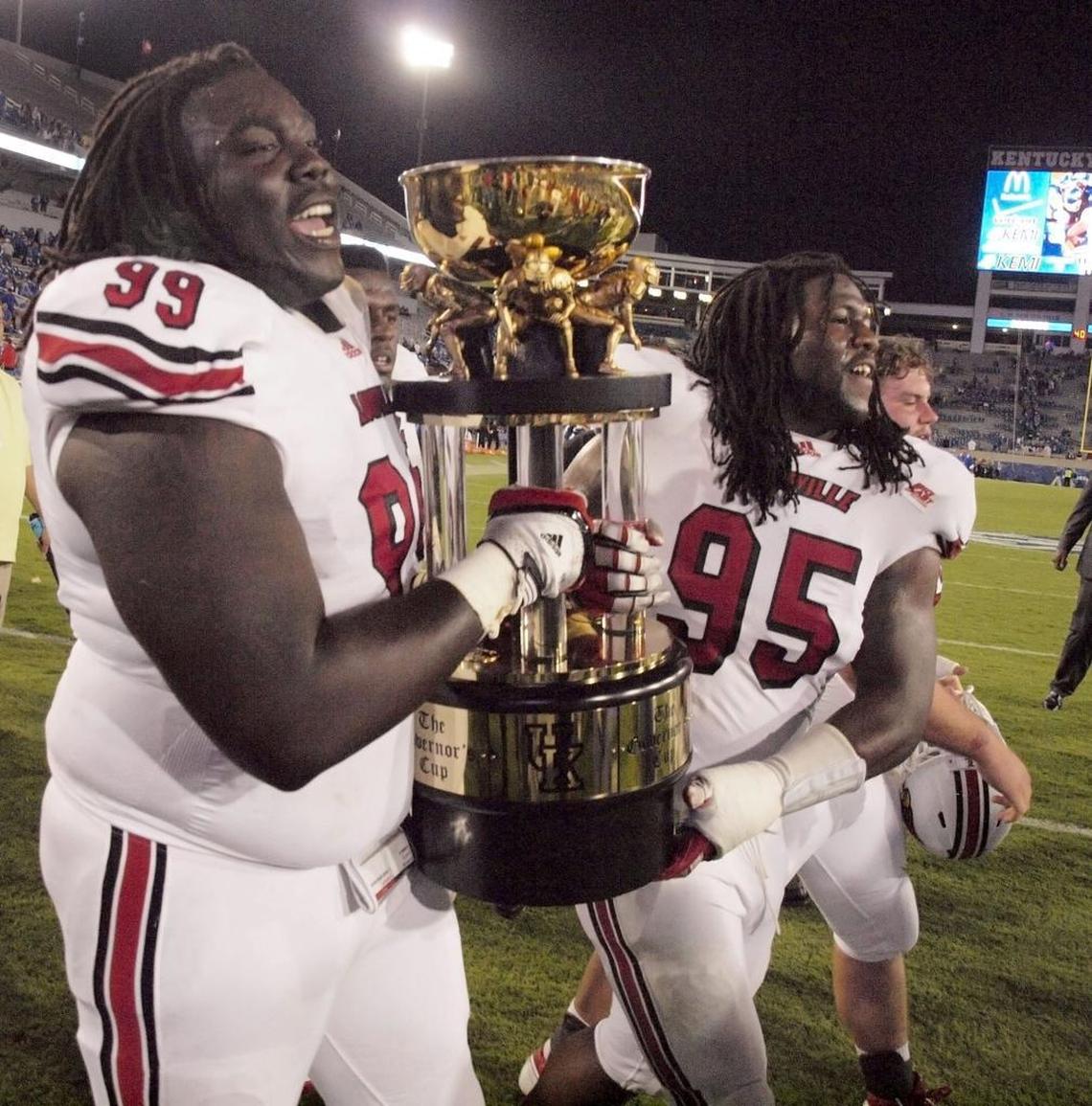 Louisville defensive linemen Jamaine Brooks (99) and Randy Salmon (95) carried the Governor’s Cup trophy off the field after the Cardinals beat Kentucky 24-17 in 2011 to snap a four-game losing streak against the Wildcats.