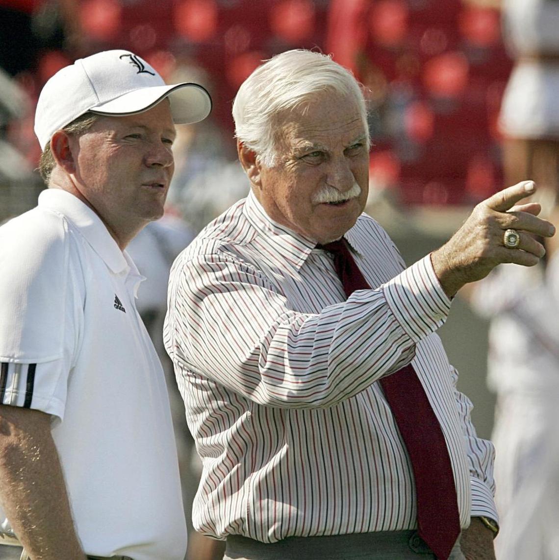 Howard Schnellenberger, right, the father of the modern Louisville football program, talked with current Cardinals head man Bobby Petrino before a game in Papa John’s Cardinal Stadium. As a player, Schnellenberger was an Associated Press First Team All-American at the University of Kentucky in 1955.