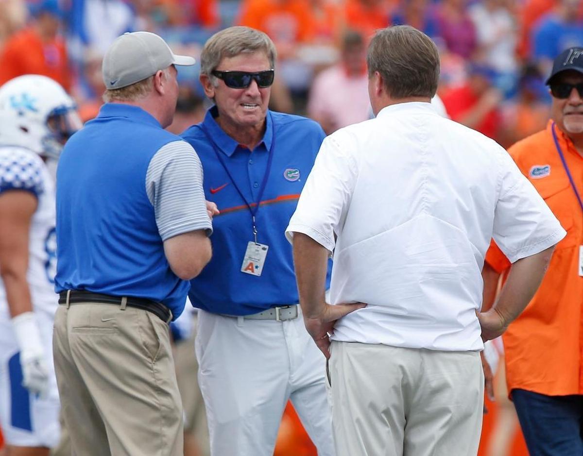 Kentucky Coach Mark Stoops, left,greeted former Florida and South Carolina head man Steve Spurrier, center, and current Florida Coach Jim McElwain before UK’s 30th-straight loss to the Gators, 45-7 last year in Gainesville.