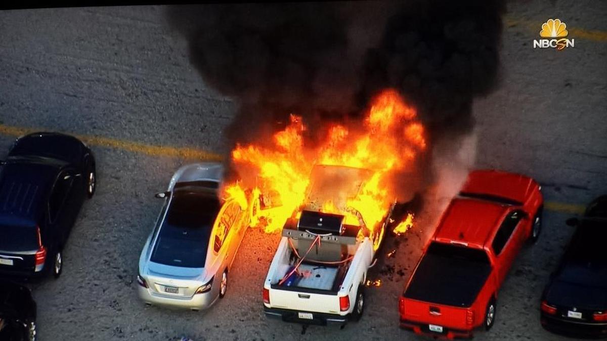 A fire that started in the cab of the white pickup (center) at last year’s Quaker State 400 at Kentucky Speedway spread to Tom Schlotman’s silver Nissan Maxima, left, totaling the car. It was Schlotman’s first NASCAR race. “Very surreal. Very surreal,” he says, “but memorable.”