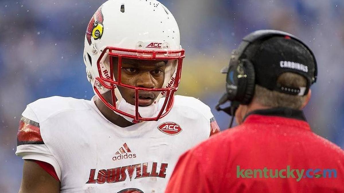 Louisville quarterback Lamar Jackson talks with head coach Bobby Petrino during the 2015 UK-U of L game at Commonwealth Stadium.