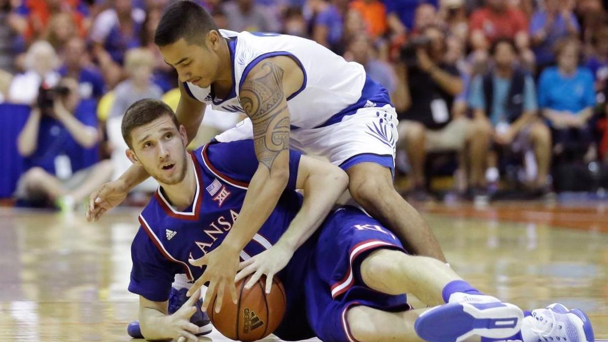 Chaminade guard Kahanu Pu'ulei-Auld, top, and Kansas guard Sviatoslav Mykhailiuk, bottom, battle for the ball in the second half of an NCAA college basketball game in the first round of the Maui Invitational Monday, Nov. 23, 2015, in Lahaina, Hawaii. Kansas won 123-72.