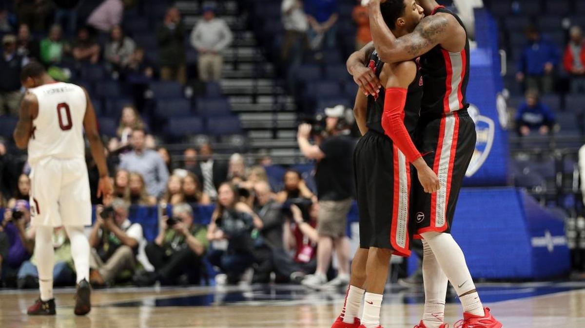 Georgia’s Charles Mann, right, hugs J.J. Frazier, left, as South Carolina's Sindarius Thornwell (0) walks off the court after an NCAA college basketball game in the Southeastern Conference tournament in Nashville, Tenn., Friday, March 11, 2016. Georgia won 65-64.