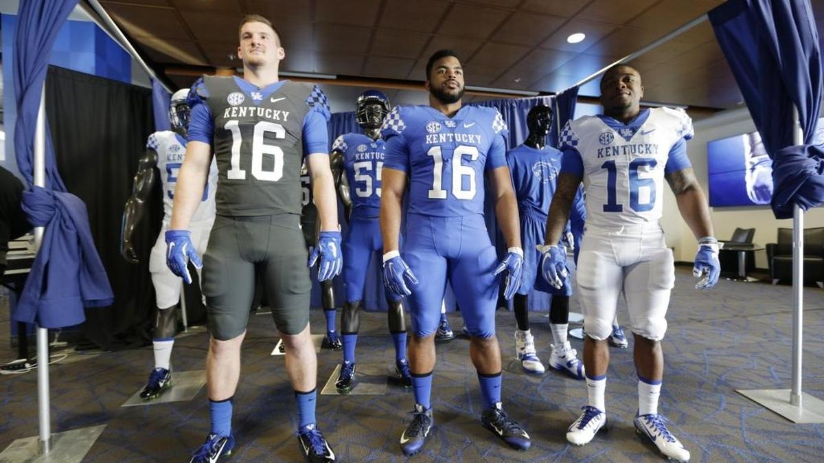 From left; C.J. Conrad, Courtney Love and Jojo Kemp modeled new uniforms at an unveiling event in the new recruiting room at Commonwealth Stadium at the University of Kentucky in Lexington, Ky, on Feb. 5, 2016.