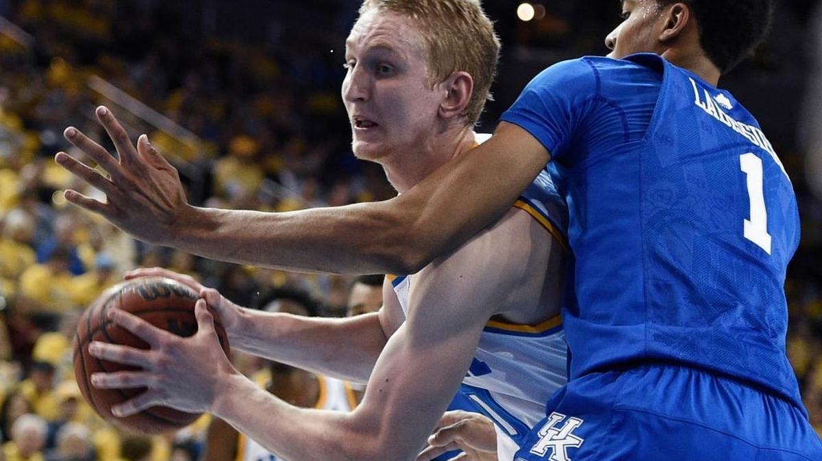 UCLA center Thomas Welsh, left, moves the ball as Kentucky forward Skal Labissiere defends during the first half of an NCAA college basketball game in Los Angeles, Thursday, Dec. 3, 2015. UCLA won 87-77.