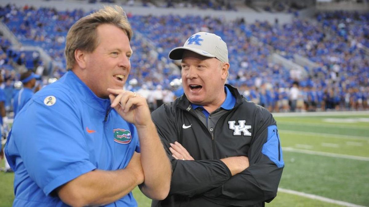 UK head coach Mark Stoops laughs with Florida head coach Jim McElwain prior last year’s game at Commonwealth Stadium. McElwain’s Gators lead the SEC East this season with a 3-1 record. Kentucky and Tennessee are tied for second at 2-2.