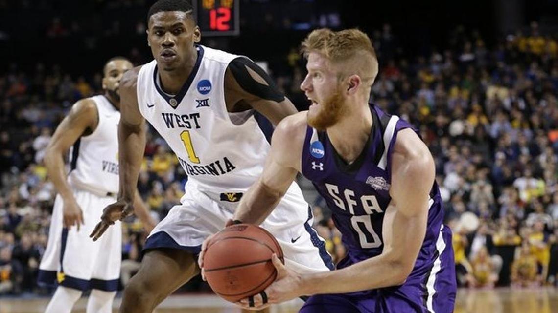 Stephen F. Austin’s Thomas Walkup (0) drives past West Virginia’s Jonathan Holton (1) during SFA’s upset win over No. 3 seed WVU in the 2016 NCAA Tournament.