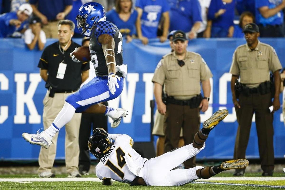 Kentucky running back Benny Snell leaped over Missouri defensive back Adam Sparks (14) as he ran the ball for a 71-yard touchdown during UK’s 40-34 victory at Kroger Field last season.