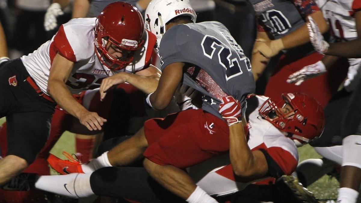 Lafayette's Cameron Morgan is pulled down by Scott County defenders in the Blanton Collier Kickoff Classic at Ishmael Stadium in Lexington, Ky., Friday, August 25, 2017. Scott County won 31-21.
