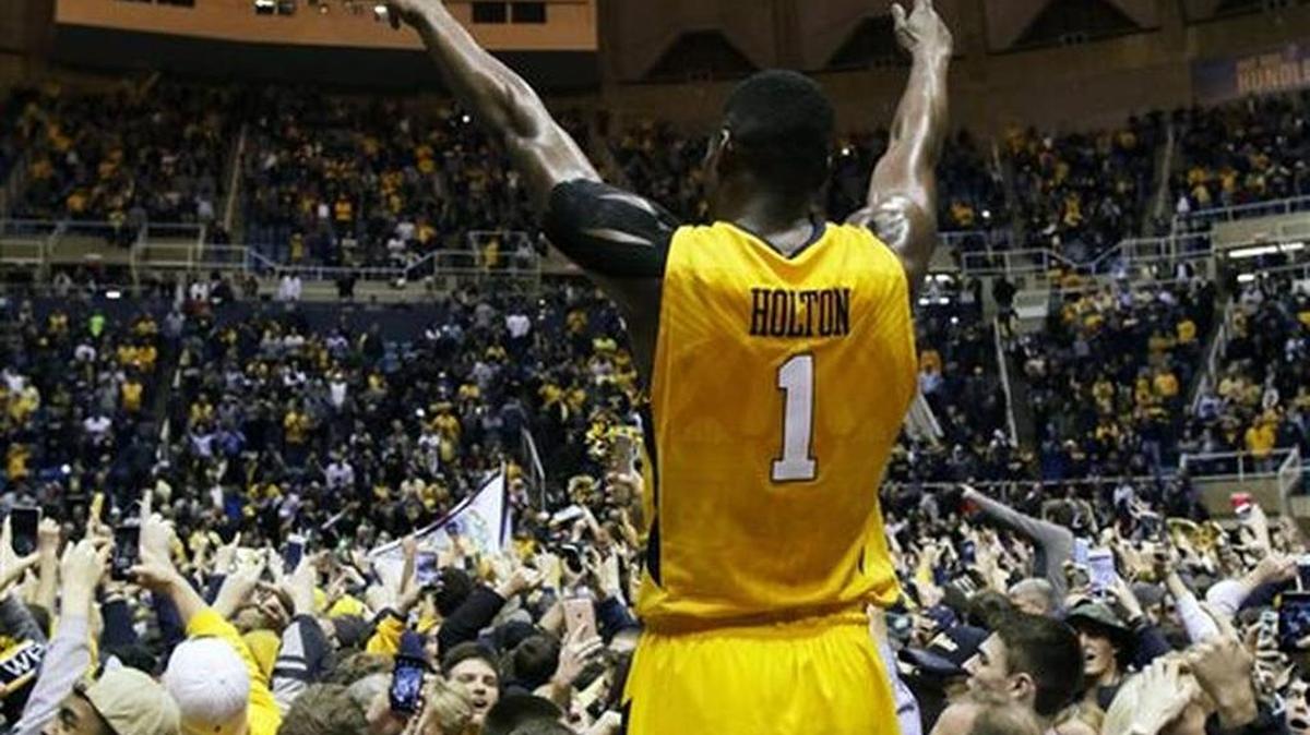 West Virginia forward Jonathan Holton (1) celebrates after his team defeated Kansas in an NCAA college basketball game, Tuesday, Jan, 12, 2016, in Morgantown, W.Va. West Virginia defeated Kansas 74-63.