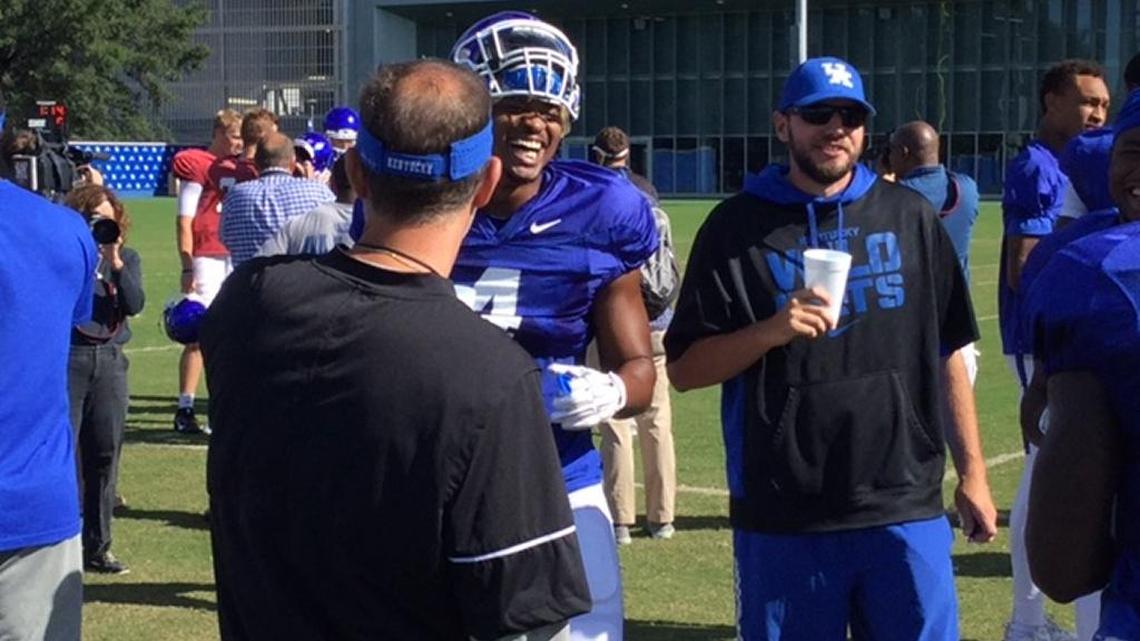 Kentucky running back Mikel Horton (4) laughs it up with offensive coordinator Eddie Gran during a break in practice on Monday.